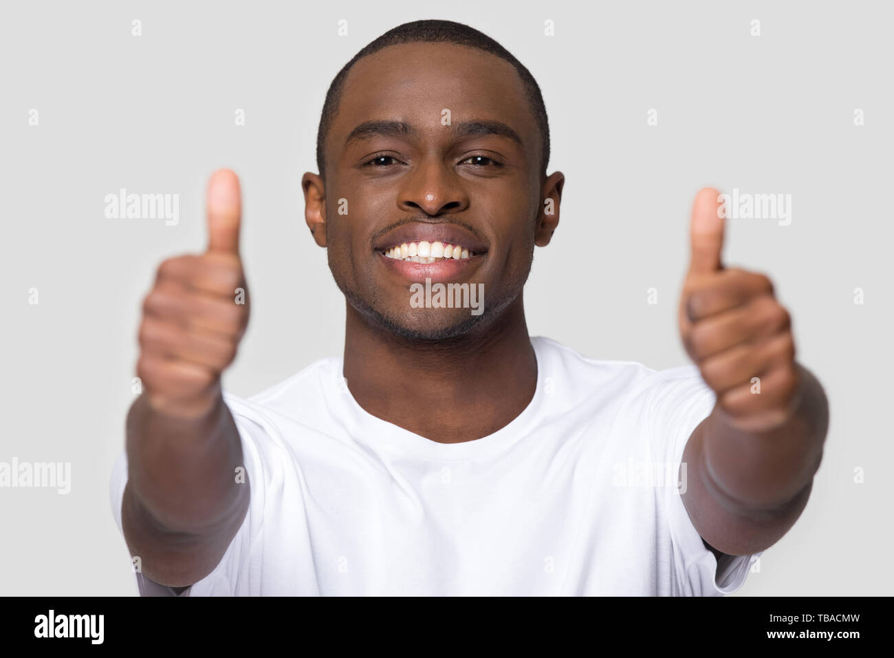 Afrikanischer Mann fühlt sich glücklich mit Daumen nach oben an der Kamera auf der Suche Stockfoto