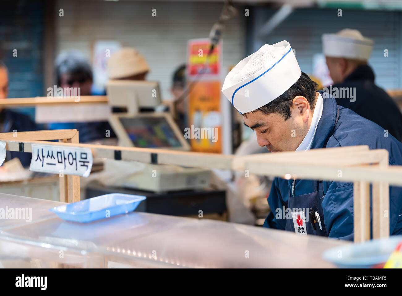 Tokyo, Japan - 30. März 2019: Äußere Market Street in Tsukiji in der Nähe von Ginza mit Anbieter mann Nahaufnahme kochen Essen zubereiten Stockfoto
