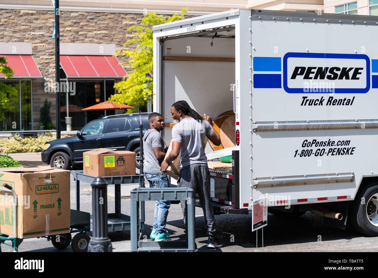 Montgomery, USA - 21. April 2018: Stadt in Alabama Street Viertel mit Stadt Bürgersteig und Menschen bewegen movers Männer Kisten packen in Penske Truck Stockfoto