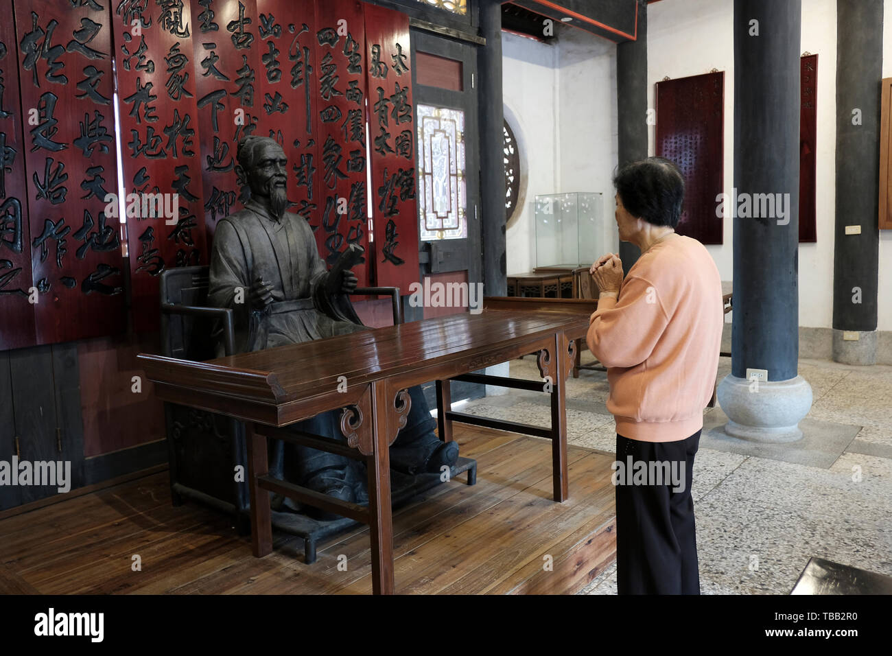 Eine Frau betet an dem Schrein, der Zhu Zi gewidmet ist und in der 1780 gegründeten Wujiang Akademie auf der Insel Kinmen in Taiwan errichtet wurde. ZhuZi war ein berühmter Rationalist der konfuzianischen Philosophie aus der Südlichen Song-Dynastie, der die frühesten Yennan-Akademie in Kinmen gründete, wo die Schüler Bildung erhalten konnten. Stockfoto