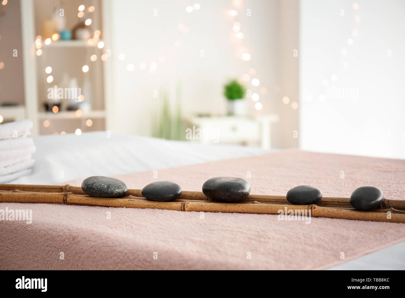 Massage Steine mit Bambus auf Tisch in Spa Salon Stockfoto