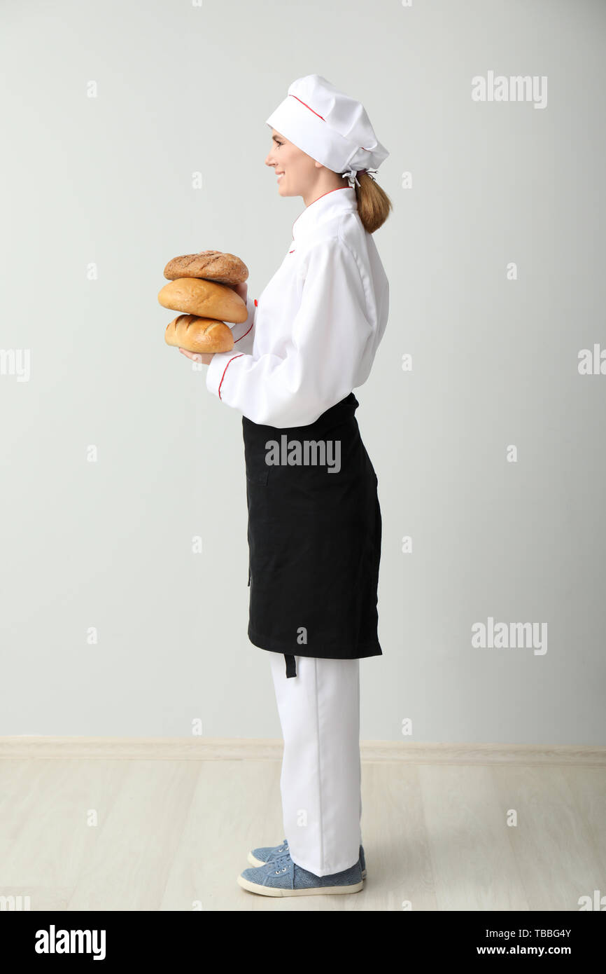 Schöne weibliche Bäcker in der Nähe von hellen Wand Stockfoto