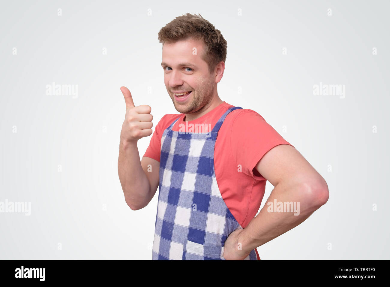 Mann in Schürze zeigen, Daumen hoch. Positive emotion Stockfoto