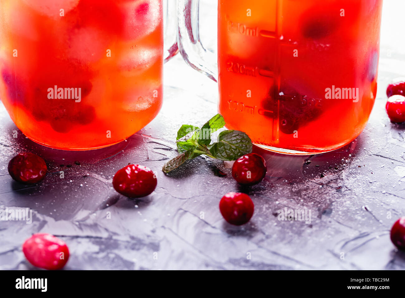 Iced hausgemachte Limonade mit Preiselbeeren, Zitrusfrüchte und frischer Minze Blatt in einem Cocktail Glas mit Strohhalm Stockfoto