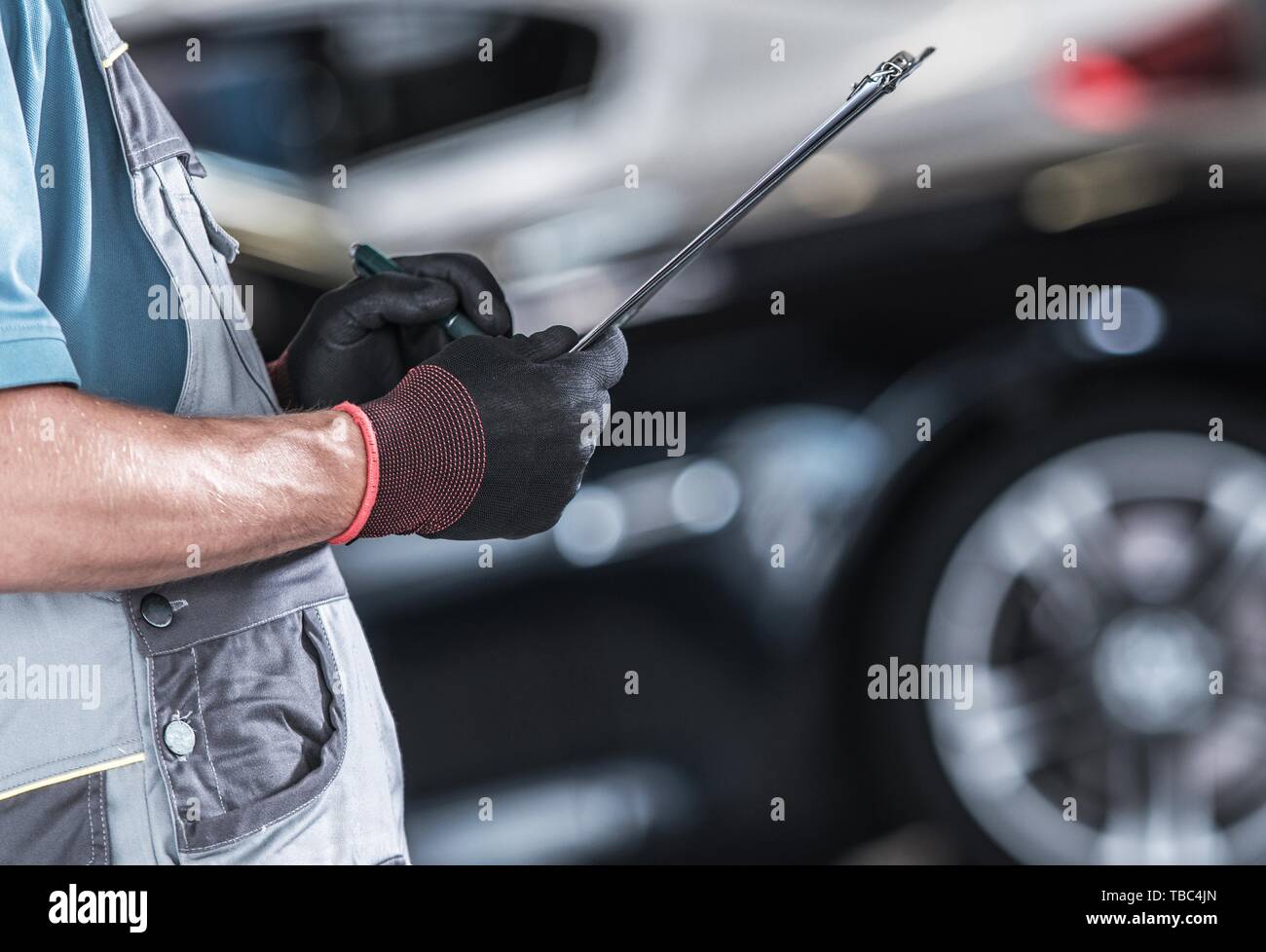 Kaukasische Automobil Arbeiter Erstellung der Dokumentation Inside zertifiziert Car Service. Closeup Foto. Stockfoto