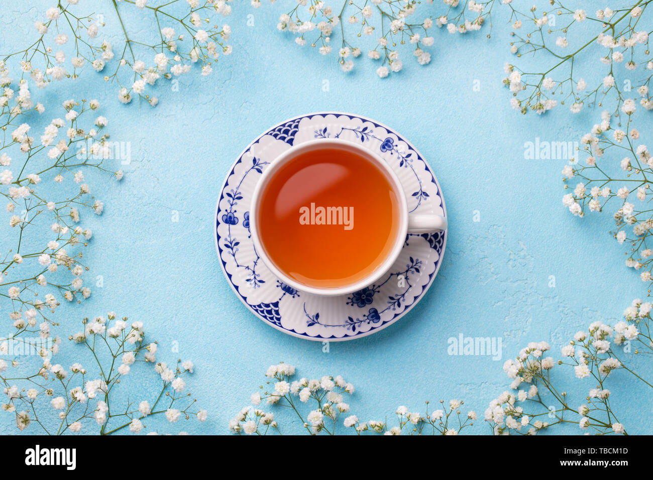 Tasse Tee mit frischen Blumen auf blauem Hintergrund. Ansicht von oben. Kopieren Sie Platz. Stockfoto