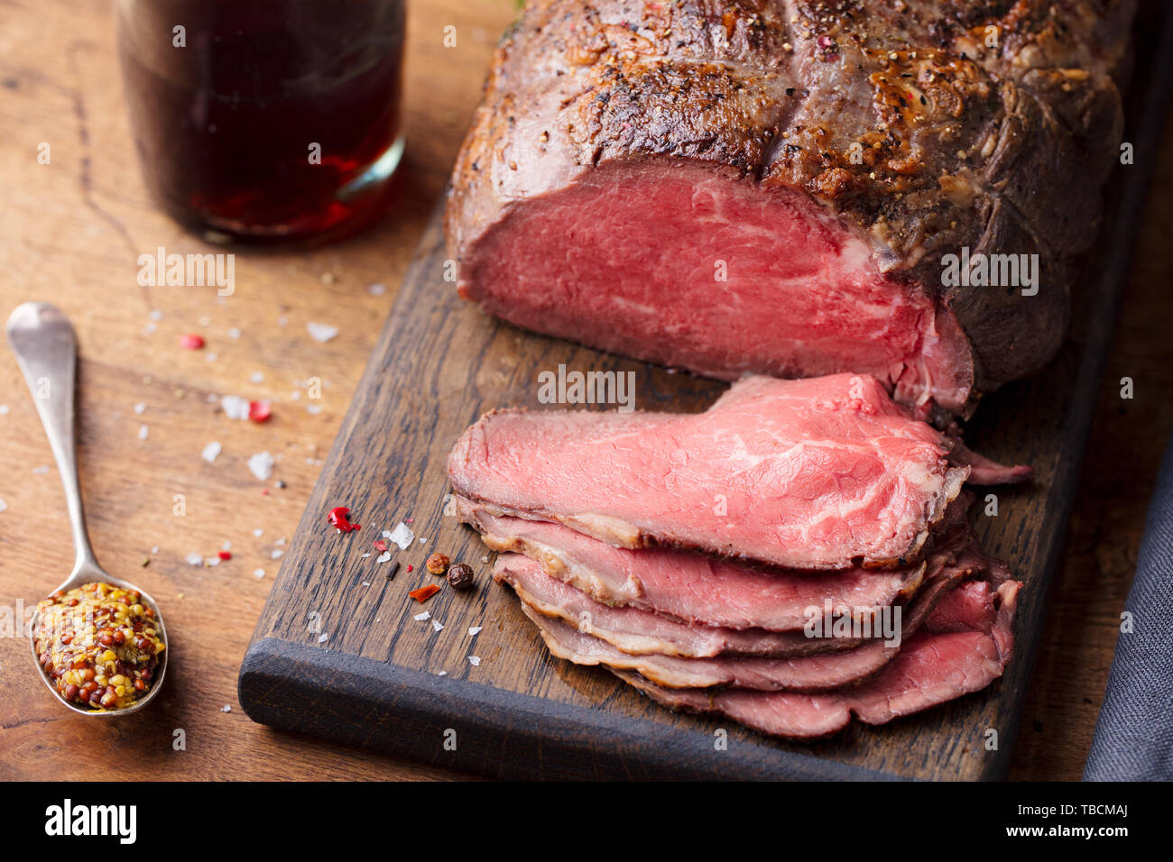 Roastbeef auf Schneidebrett mit einem Glas Wein. Holz- Hintergrund. Close Up. Stockfoto
