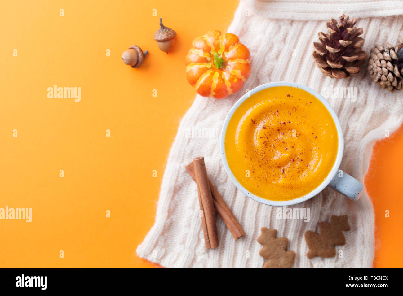 Kürbis Latte mit Gewürzen. Versoffenes Cocktail. Orange hinterlegt. Ansicht von oben. Kopieren Sie Platz. Stockfoto