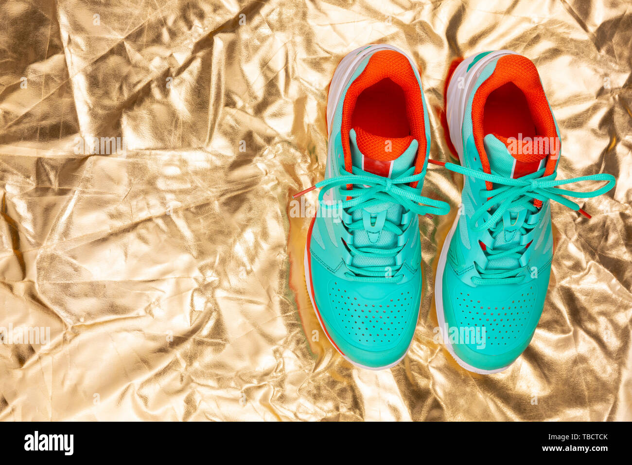 Rot, hellblau, weiß, Paar neue Tennisschuhe im Studio Schuß über reflektierende goldenen Hintergrund. Direkt von oben. Stockfoto
