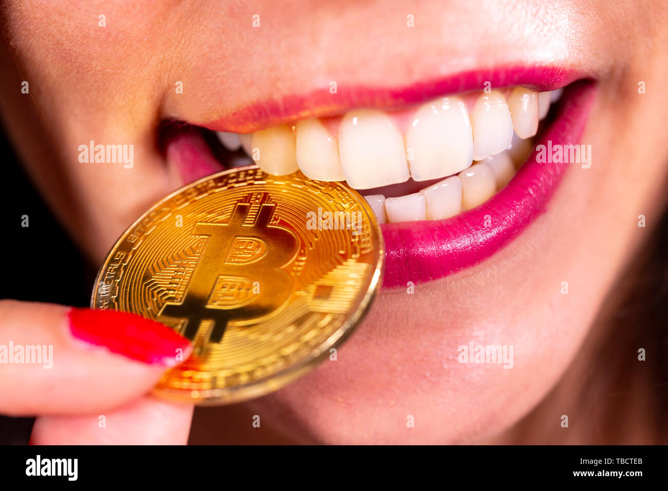 Virtuelle cryptocurrency Geld Bitcoin goldene Münze im Mund der Frau mit  roten Nagellack. Schöne weibliche Modell lächelnd. Die Zukunft des Geldes.  Co Stockfotografie - Alamy