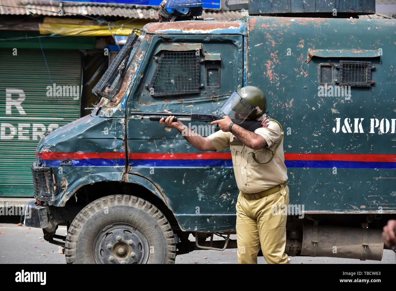 Ein Polizist soll seine Waffe gegen Demonstranten während eines Protestes. Auseinandersetzungen nach dem Höhepunkt der gemeindlichen Freitagsgebet hier in Srinagar, die Al-Quds-Tag zu kennzeichnen. Kerben der Jugend wurden verletzt, als die Kräfte der Gas- und Pellets reißen gefeuert. Die Aufforderung zur Einhaltung wurde von pro-Freiheit separatistische Gruppe. Stockfoto