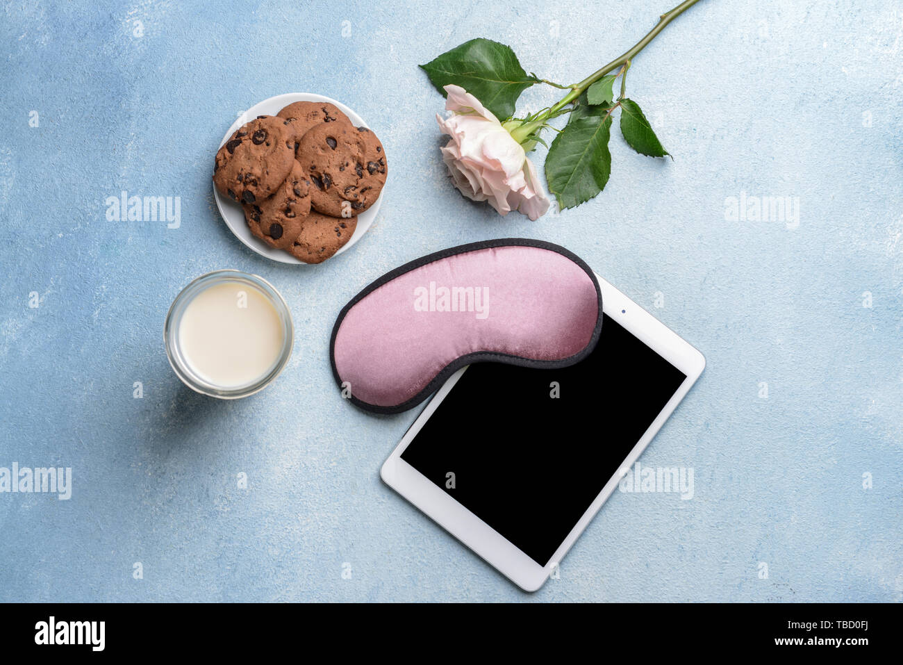 Komposition mit Schlafbrille, Frühstück und Tablet Computer auf farbigen Hintergrund Stockfoto