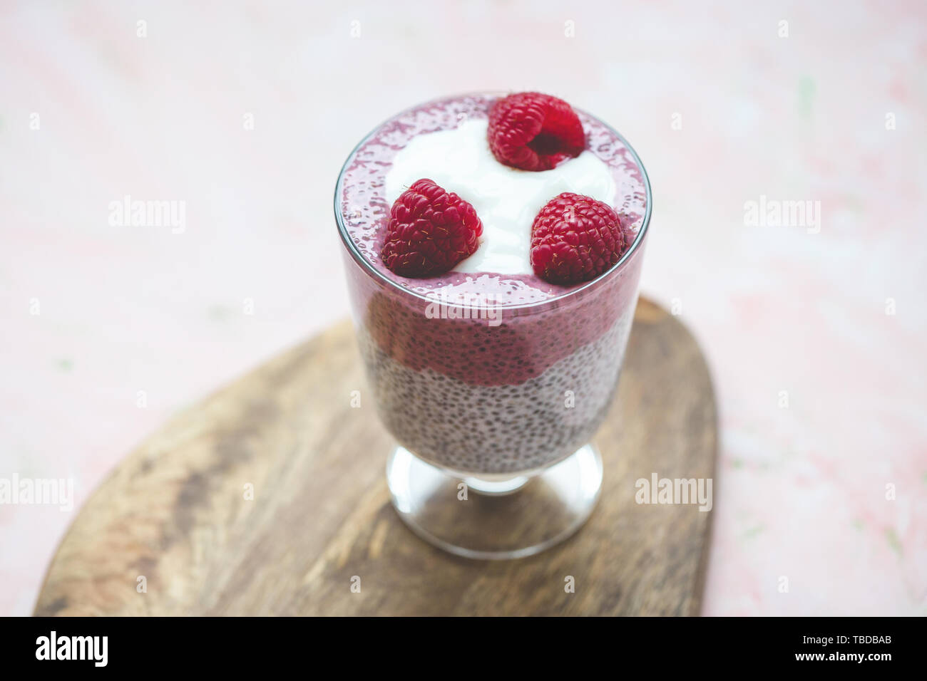 Chia Samen parfait Milchreis mit Mandeln Milch, Joghurt, pinkfarbenen Drachenfrucht pitaya Pulver und Himbeeren Dessert im Glas. Superfood und veganes Essen conce Stockfoto