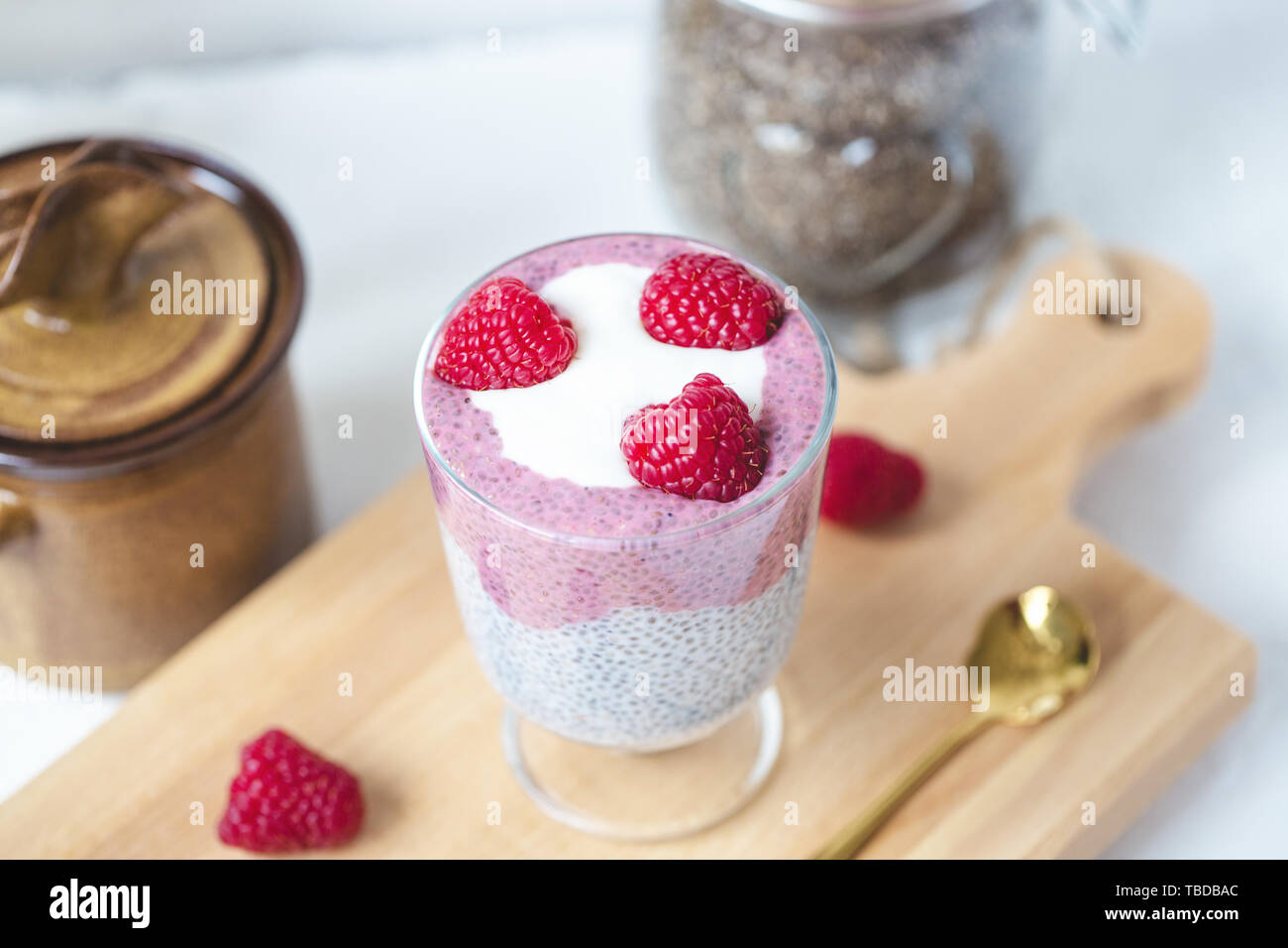 Chia Samen parfait Milchreis mit Mandeln Milch, Joghurt, pinkfarbenen Drachenfrucht pitaya Pulver und Himbeeren Dessert im Glas. Superfood und veganes Essen conce Stockfoto
