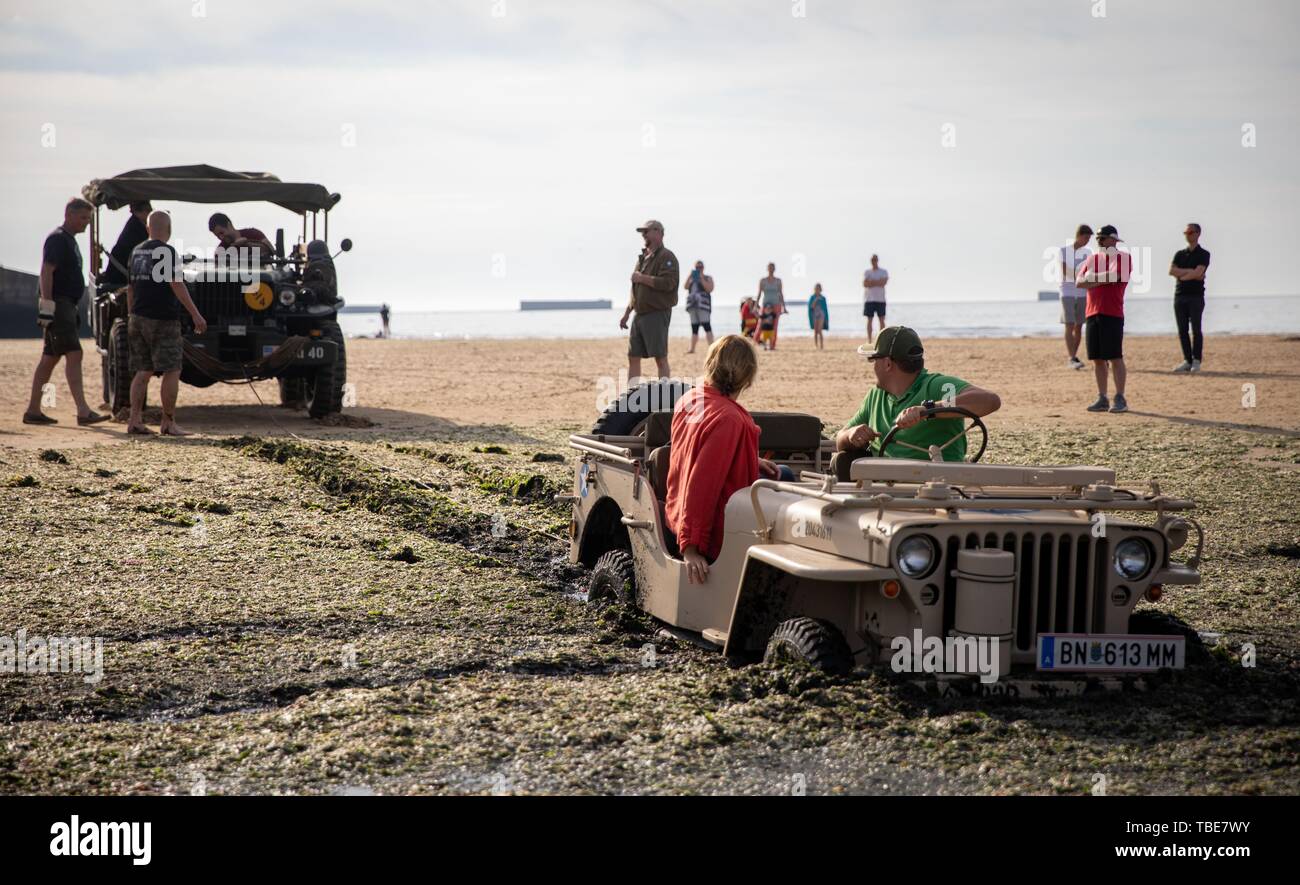 Frankreich. 01. Juni 2019, France (Frankreich), Arromanches-Les-Bains: ein Jeep fuhr in den Schlamm an Gold Strand zwischen den Resten der ehemaligen Hafen. Nach der Landung der alliierten Truppen im Zweiten Weltkrieg, einer der zwei künstliche Häfen (Mulberry B) gebaut wurde an der Küste von Arromanches-les-Bains, durch die Truppen und liefert an Land gebracht wurden. 06.06.2019 ist der 75. Jahrestag der Landung der alliierten Truppen in der Normandie (D-Day). Foto: Kay Nietfeld/dpa Stockfoto