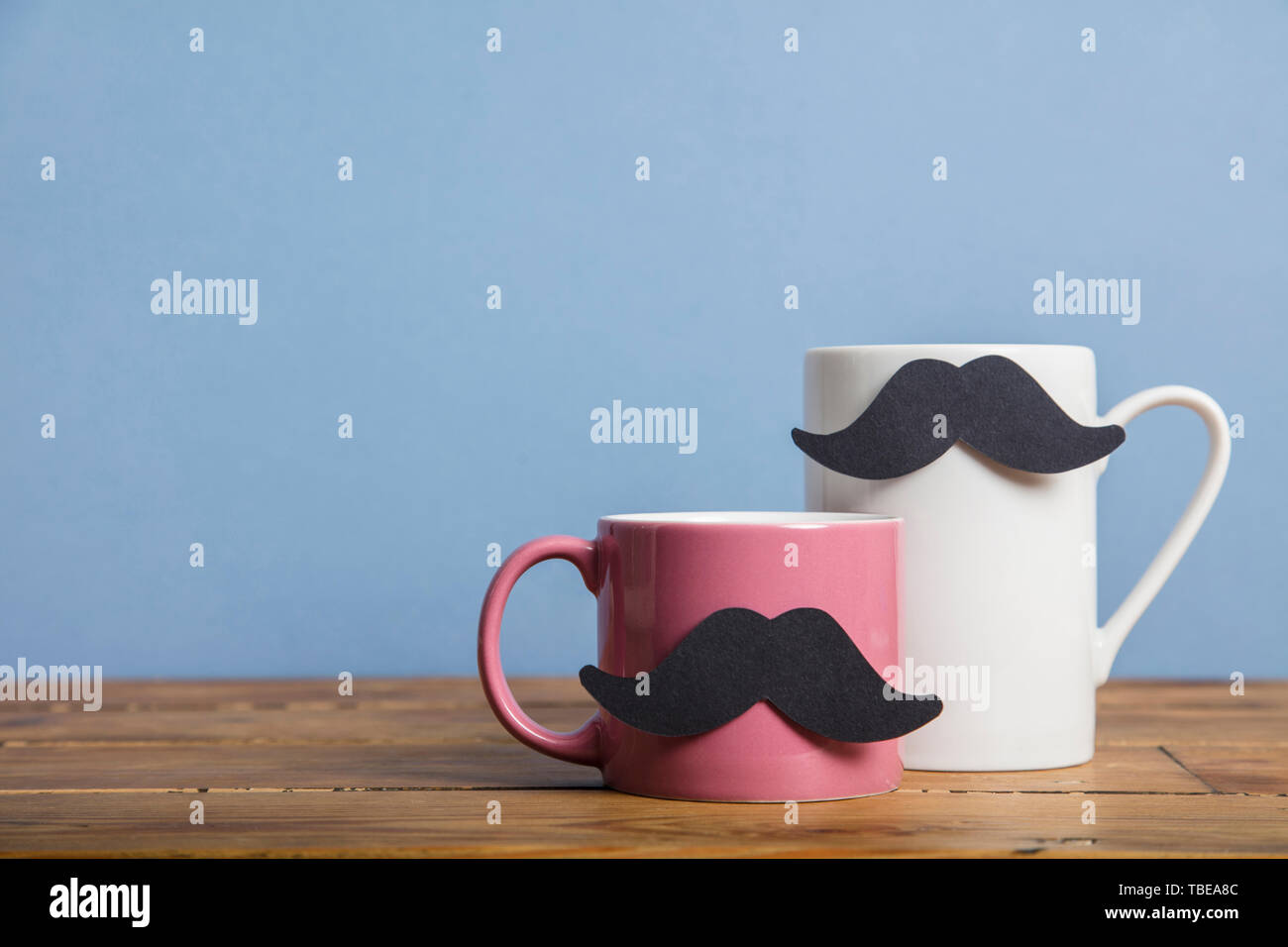 Vatertag Kaffeebecher mit einem Papier Schnurrbart vor einem blauen Hintergrund Stockfoto