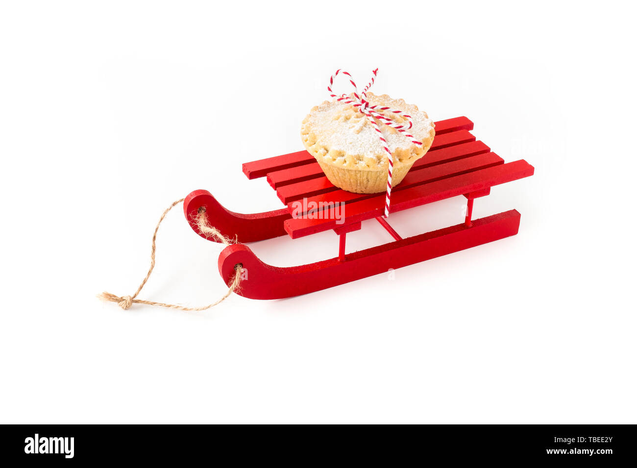 Rote hölzerne Schlitten mit Mince Pie isoliert auf weißem Hintergrund. Schrägansicht. Stockfoto