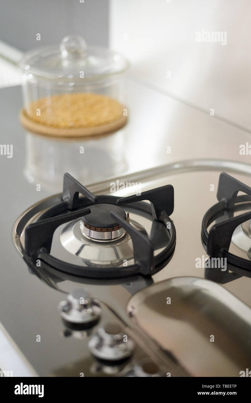 Detail einer gas Küche aus rostfreiem Stahl, mit einem transparenten Behälter mit Getreide gefüllt Stockfoto