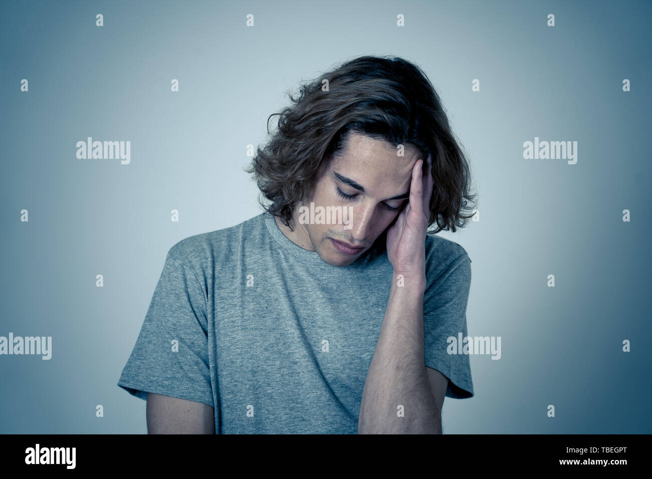 Junger Teenager besorgt und durchdachte leiden unter Migräne bei großen Schmerzen suchen. Portrait der tausendjährigen Mann in emotionalen Schmerz. In der Gesichtsbehandlung expressi Stockfoto