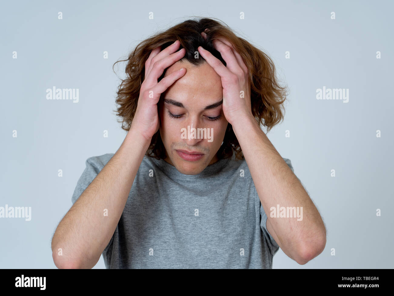 Junger Teenager besorgt und durchdachte leiden unter Migräne bei großen Schmerzen suchen. Portrait der tausendjährigen Mann in emotionalen Schmerz. In der Gesichtsbehandlung expressi Stockfoto