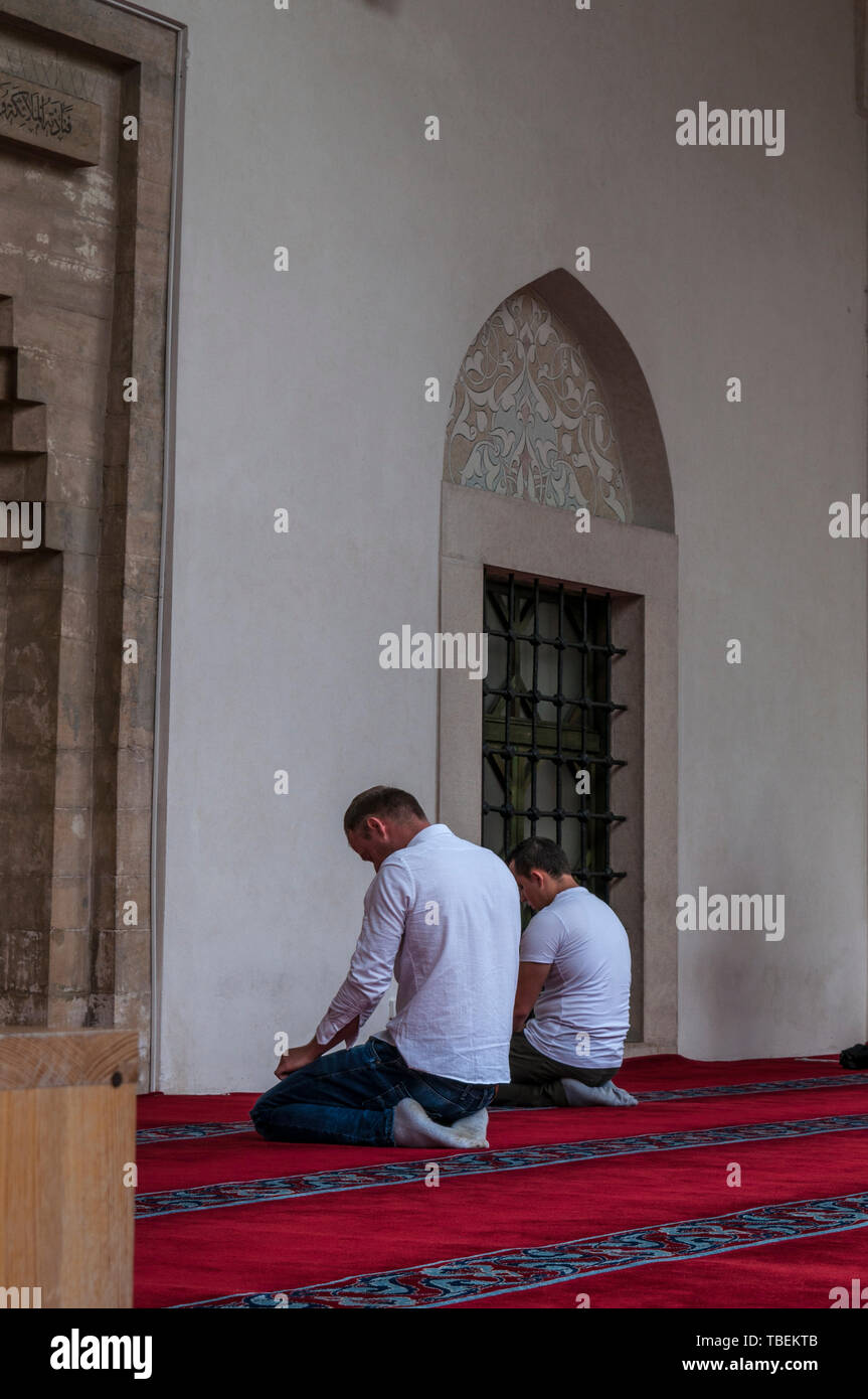 Sarajevo, Bosnien: muslimische Männer beten in Richtung Mekka außerhalb der Gazi-husrev-Beg Moschee (1532) in der Altstadt Bascarsija Nachbarschaft Stockfoto