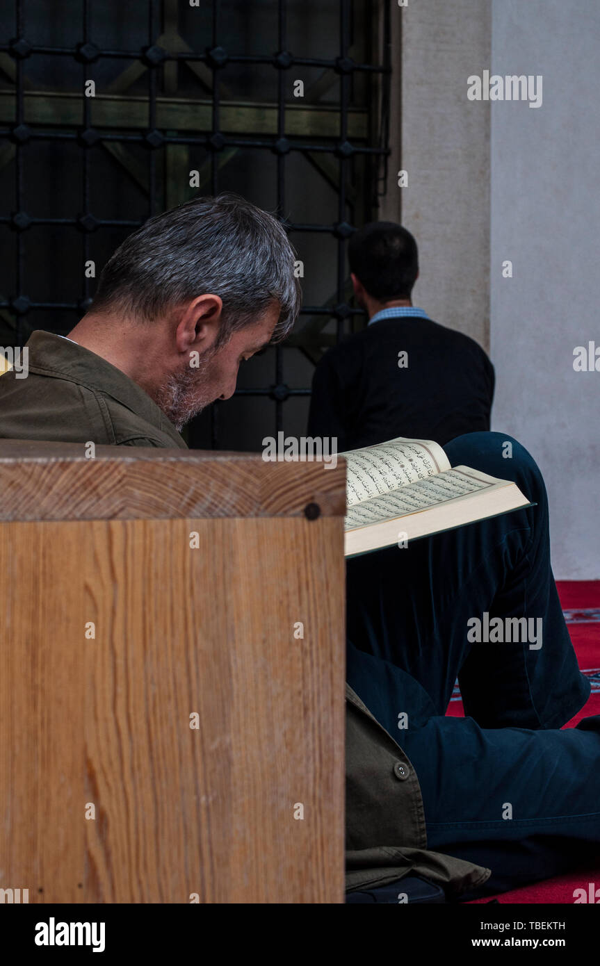 Sarajevo, Bosnien: ein muslimischer Mann lesen den Koran in der Nähe von Bruder beten in Richtung Mekka außerhalb der Gazi-husrev-Beg Moschee (1532) Stockfoto