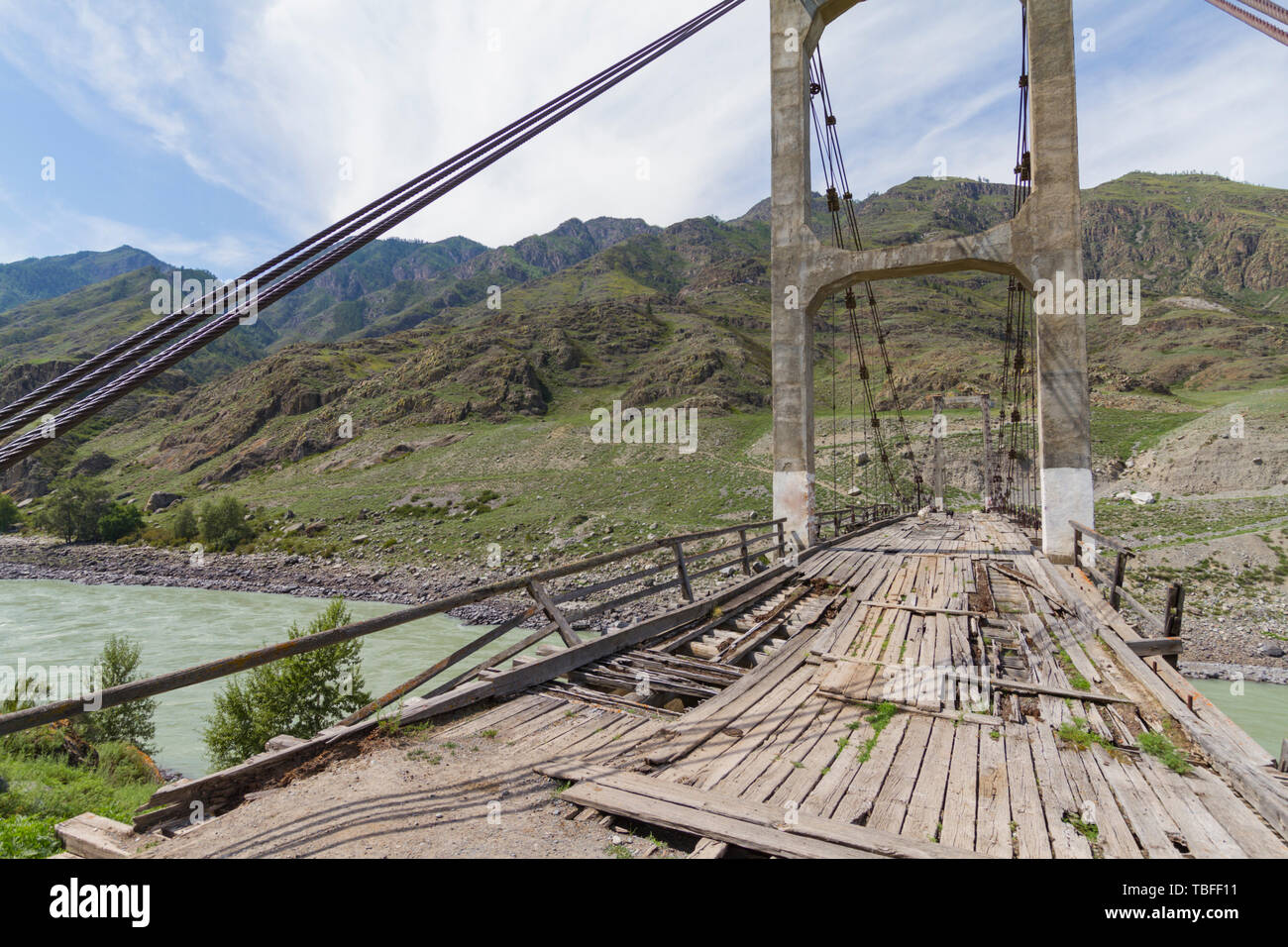 Alte Holzbrücke auf Eisen Seile durch die Katun Flusses. Sommer sonnige Zeit. Close Up. Stockfoto