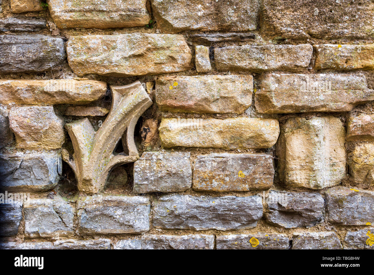 Kirche stein ornament Fragmente in einem Cotswold stone wall Embedded Stockfoto