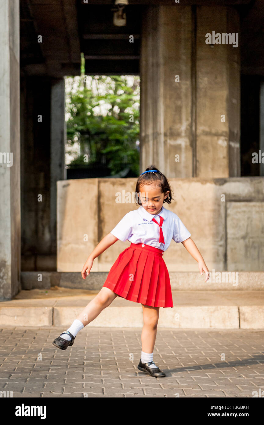 Ein wenig Thai Girl tanzt einen traditionellen thailändischen Tanz auf den Straßen von Bangkok als Straße Unterhaltung. Stockfoto