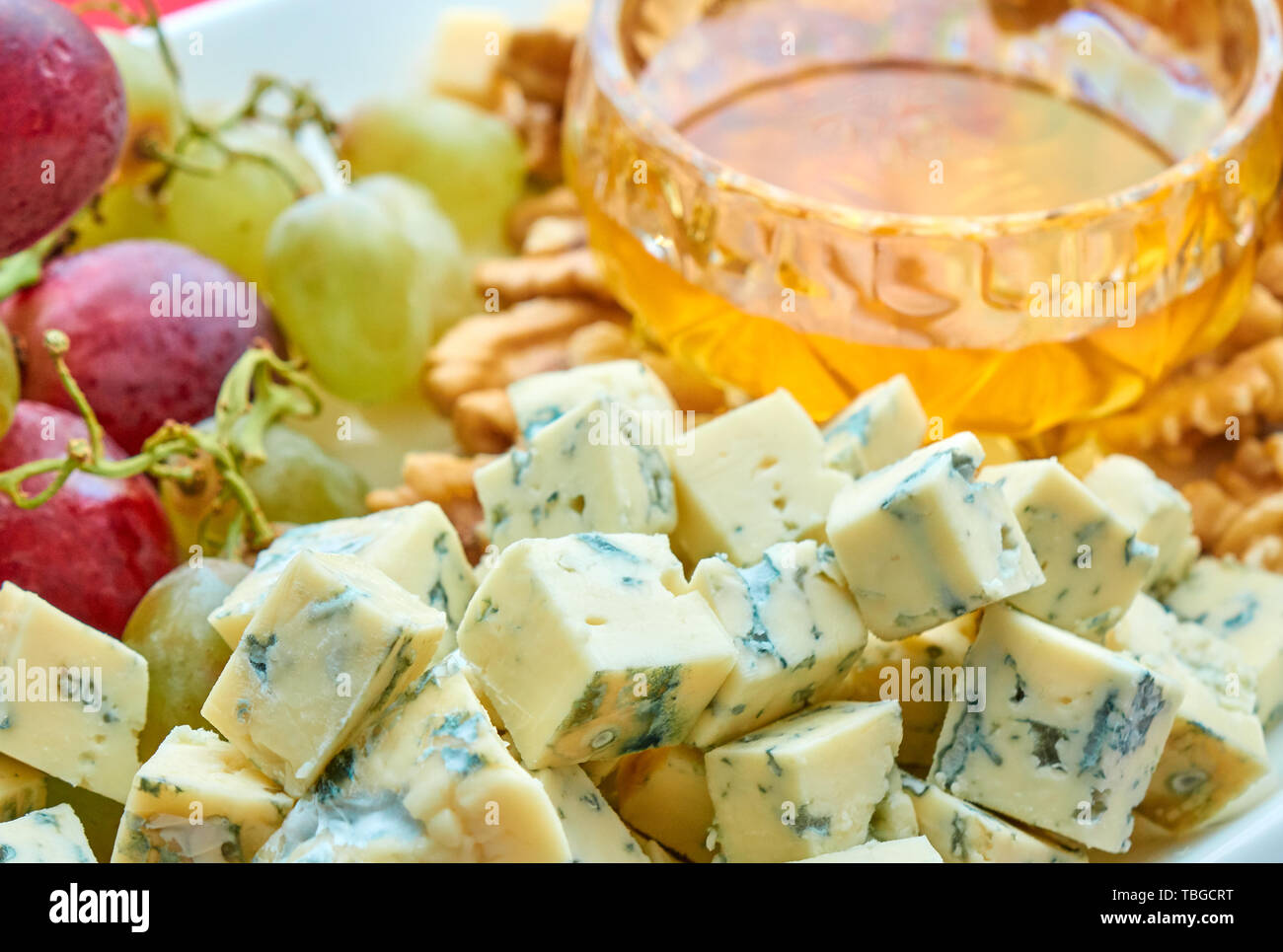 Verschiedene Käse, Weintrauben, Nüssen und Honig gourment sortierten close-up Stockfoto