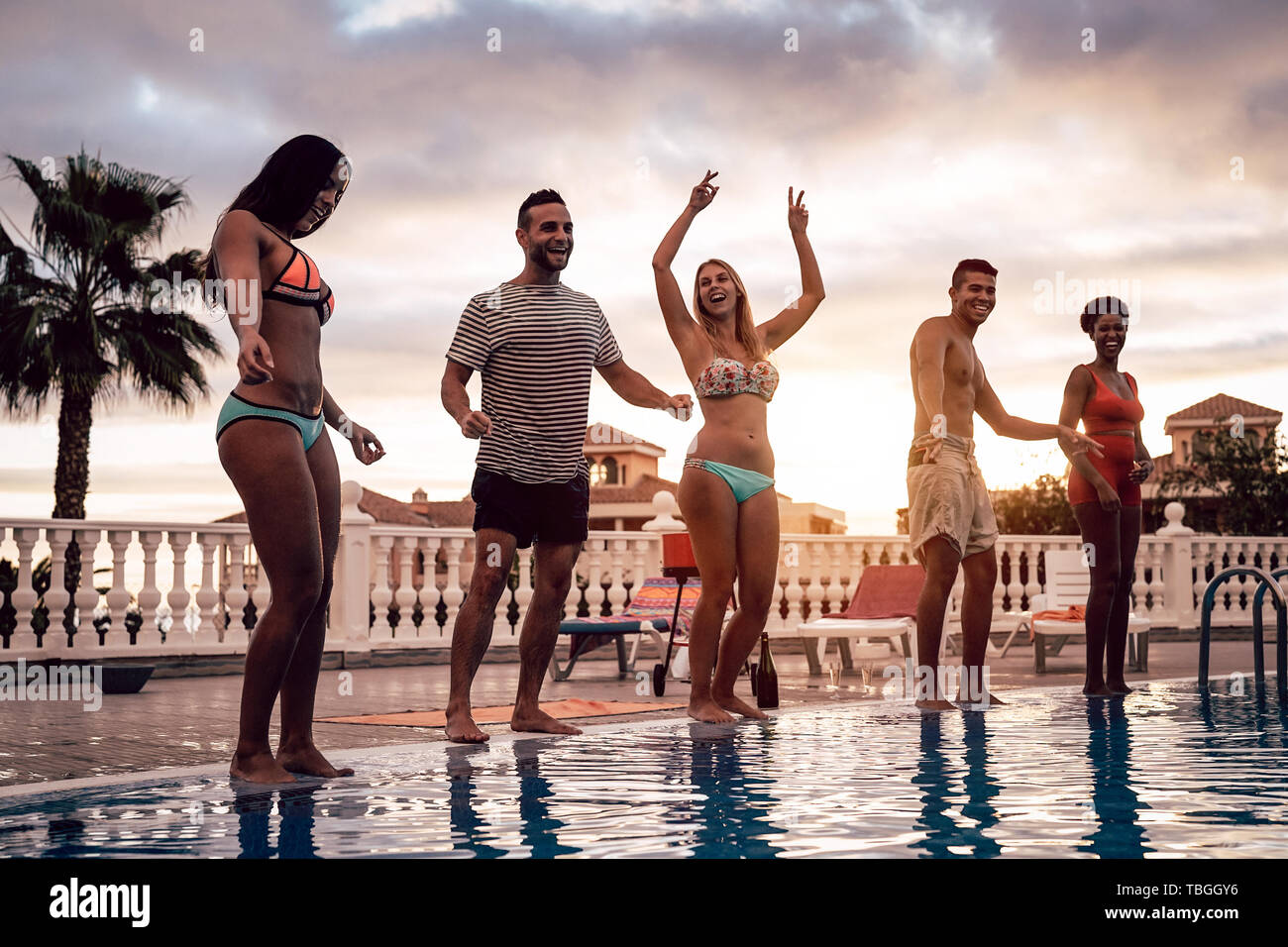 Gruppe der glücklichen Freunde tanzen am Pool Party bei Sonnenuntergang - Junge tausendjährigen Menschen Spaß in einem tropischen Luxus Resort Stockfoto