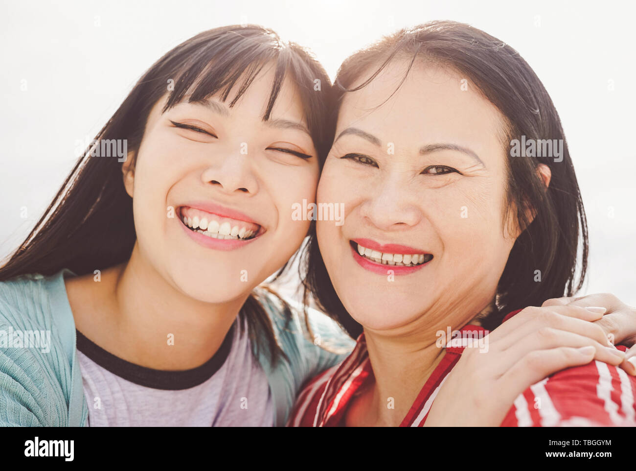 Asiatische Mutter und Tochter umarmen Outdoor - Glückliche chinesischen Familie genießen Zeit außerhalb - Elternschaft, Liebe und Menschen lifestyle Konzept Stockfoto