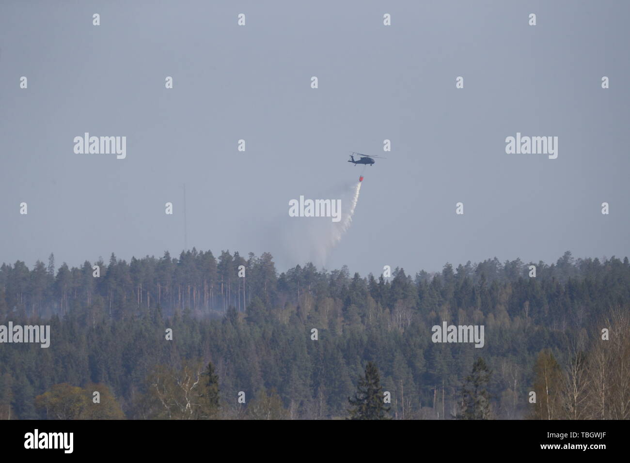 Hubschrauber wasser Bomben über den Waldbrand nördlich von Tjällmo. Stockfoto