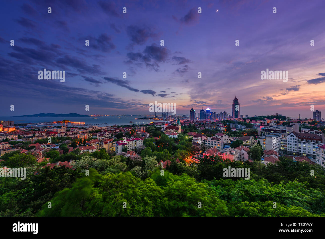 Fushan Bucht, Qingdao, die Sonne strahlt am Ufer des Fushan Bucht in Qingdao am Abend. Farbe Wolken schweben, Wellen, eine schöne Urban szenische Leitung von Qingdao Stockfoto
