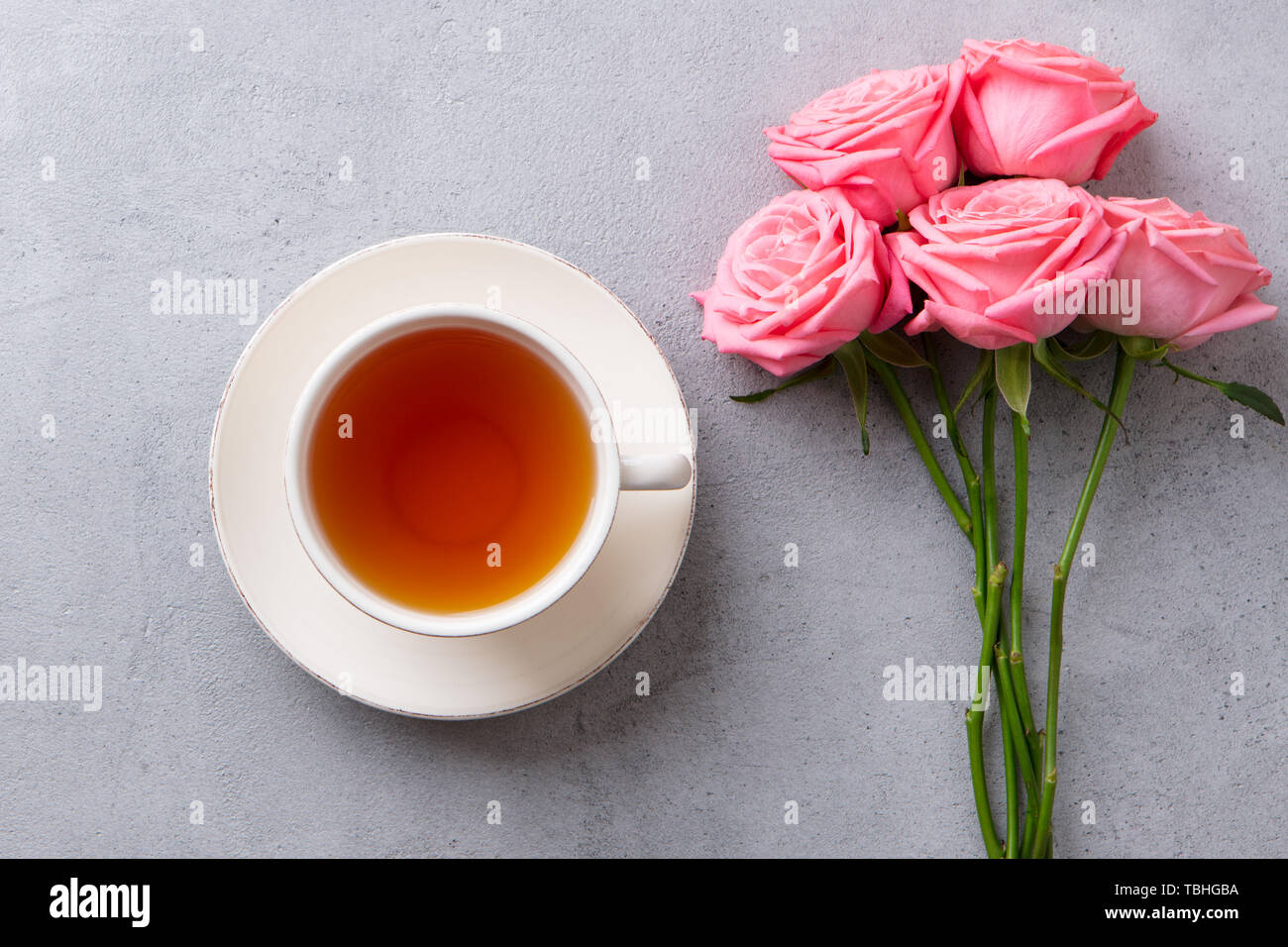 Tasse Tee mit rosa Rose. Ansicht von oben. Kopieren Sie Platz. Grauen Stein Hintergrund. Stockfoto