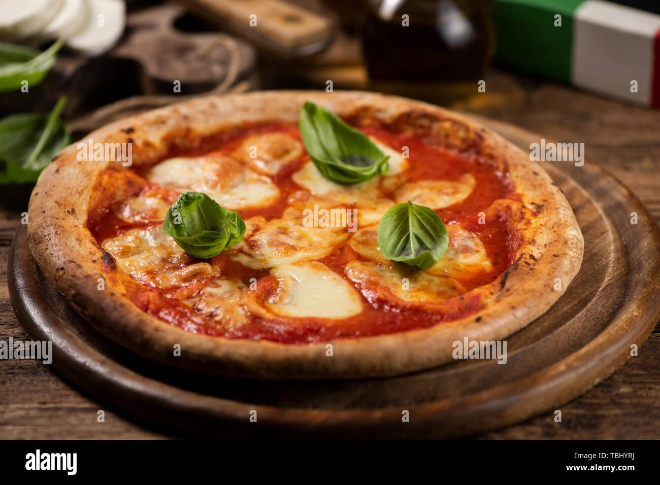 Italienische Pizza Margherita auf einem rustikalen Holztisch. Nahaufnahme Stockfoto