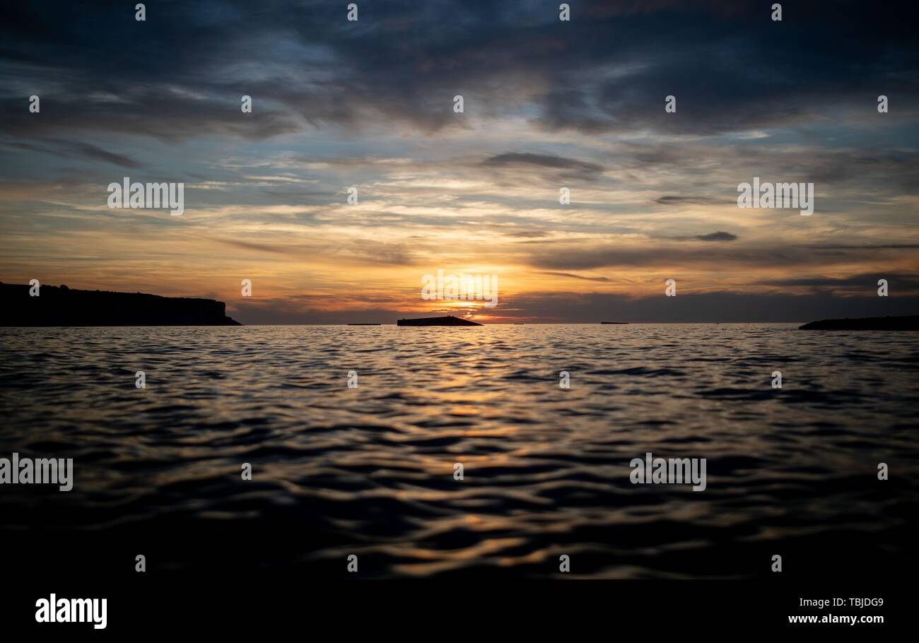 Arromanches-Les-Bains, Frankreich. 02 Juni, 2019. 01. Juni 2019, France (Frankreich), Arromanches-Les-Bains: Überreste des ehemaligen Hafen kann bei Gold Strand während der Ebbe in den Sonnenuntergang gesehen werden. Nach der Landung der alliierten Truppen eine der zwei künstliche Häfen (Mulberry B) gebaut wurde an der Küste von Arromanches-les-Bains, durch die Truppen und liefert an Land gebracht wurden. 06.06.2019 ist der 75. Jahrestag der Landung der alliierten Truppen in der Normandie (D-Day). Quelle: dpa Picture alliance/Alamy leben Nachrichten Stockfoto