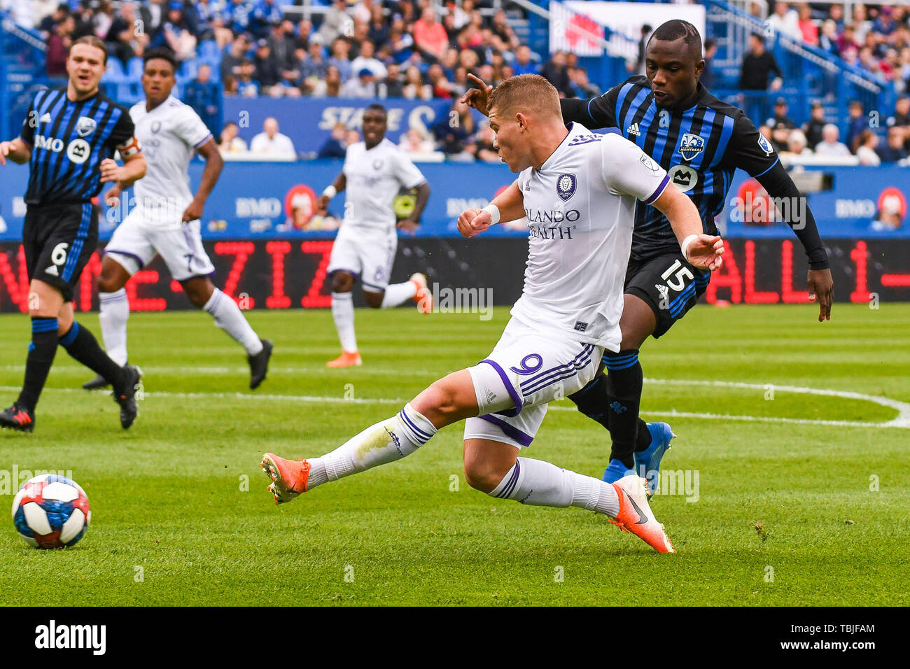 Montreal, Kanada. 01 Juni, 2019. Orlando Stadt SC vorwärts Chris Mueller (9) kickt den Ball vor Montreal Impact defender Zachary Brault-Guillard (15) Ihm während Orlando Stadt SC am Montreal Impact Spiel bei Saputo Stadium in Montreal, Kanada erreicht. David Kirouac/CSM/Alamy leben Nachrichten Stockfoto