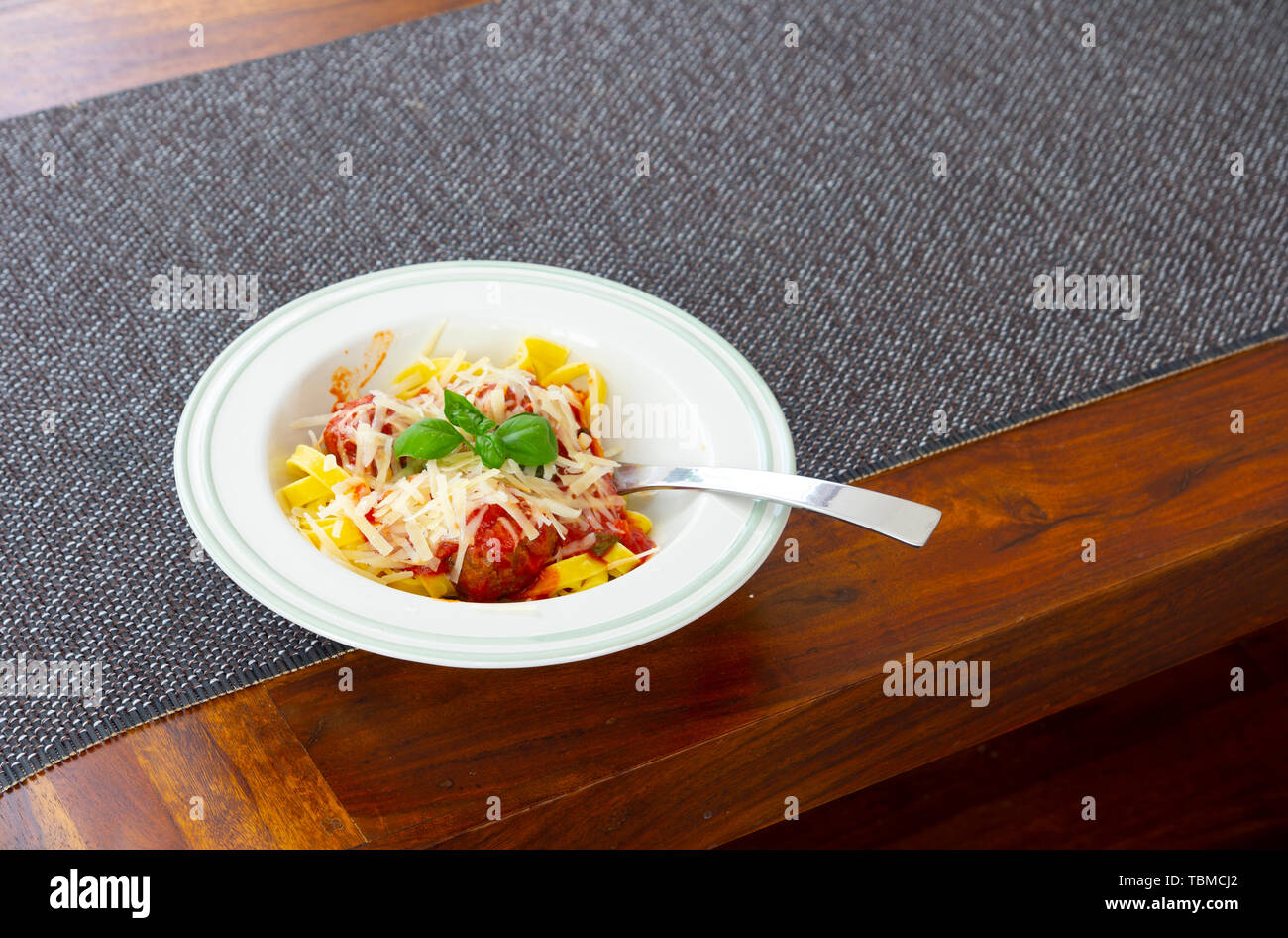 italienische Pasta Bolognese mit Basilikumblättern und Parmesankäse Stockfoto