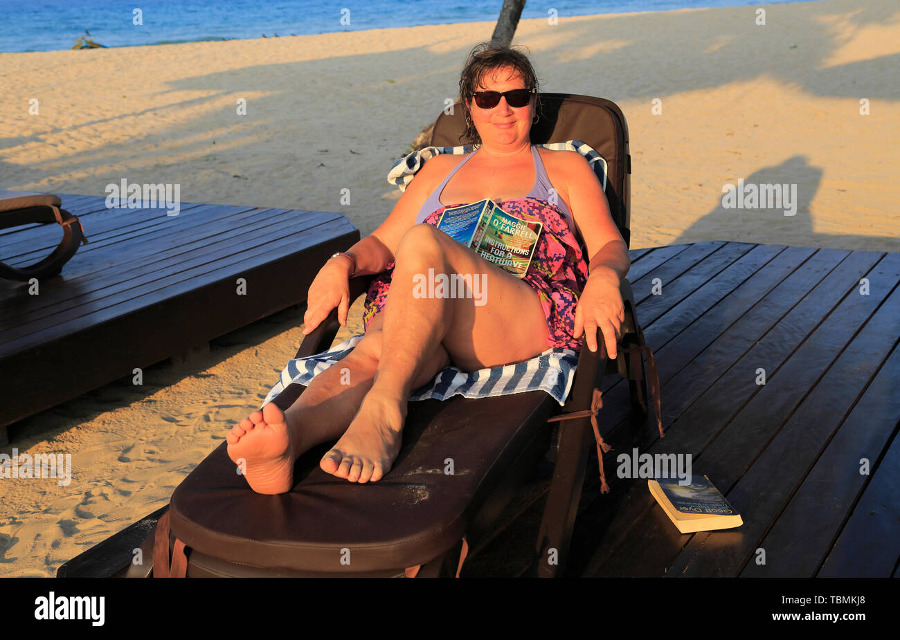 Frau Entspannen im Liegestuhl Nilavelli Strand, in der Nähe von Trincomalee, östlichen Provinz, Sri Lanka, Asien Stockfoto