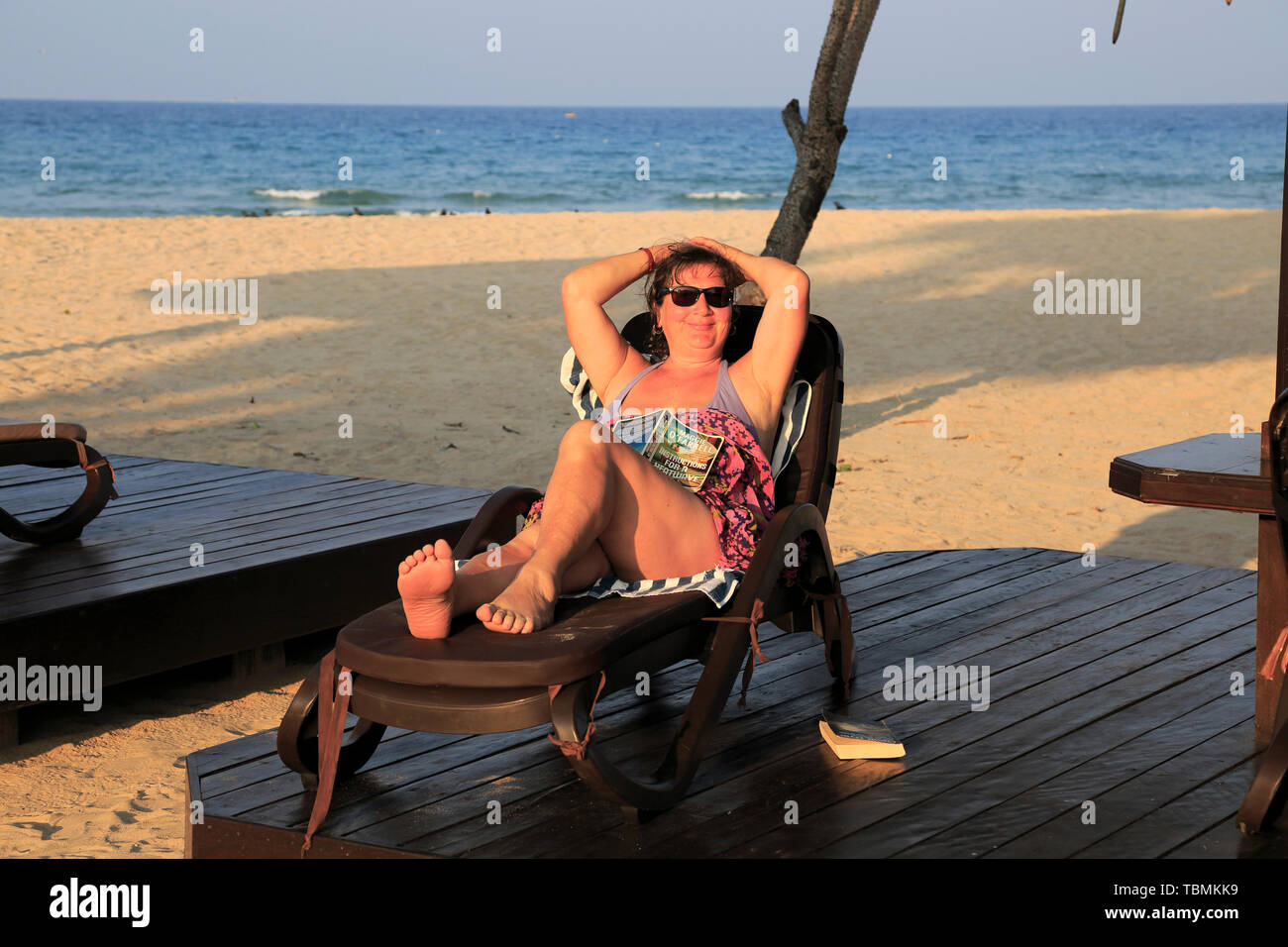 Frau Entspannen im Liegestuhl Nilavelli Strand, in der Nähe von Trincomalee, östlichen Provinz, Sri Lanka, Asien Stockfoto