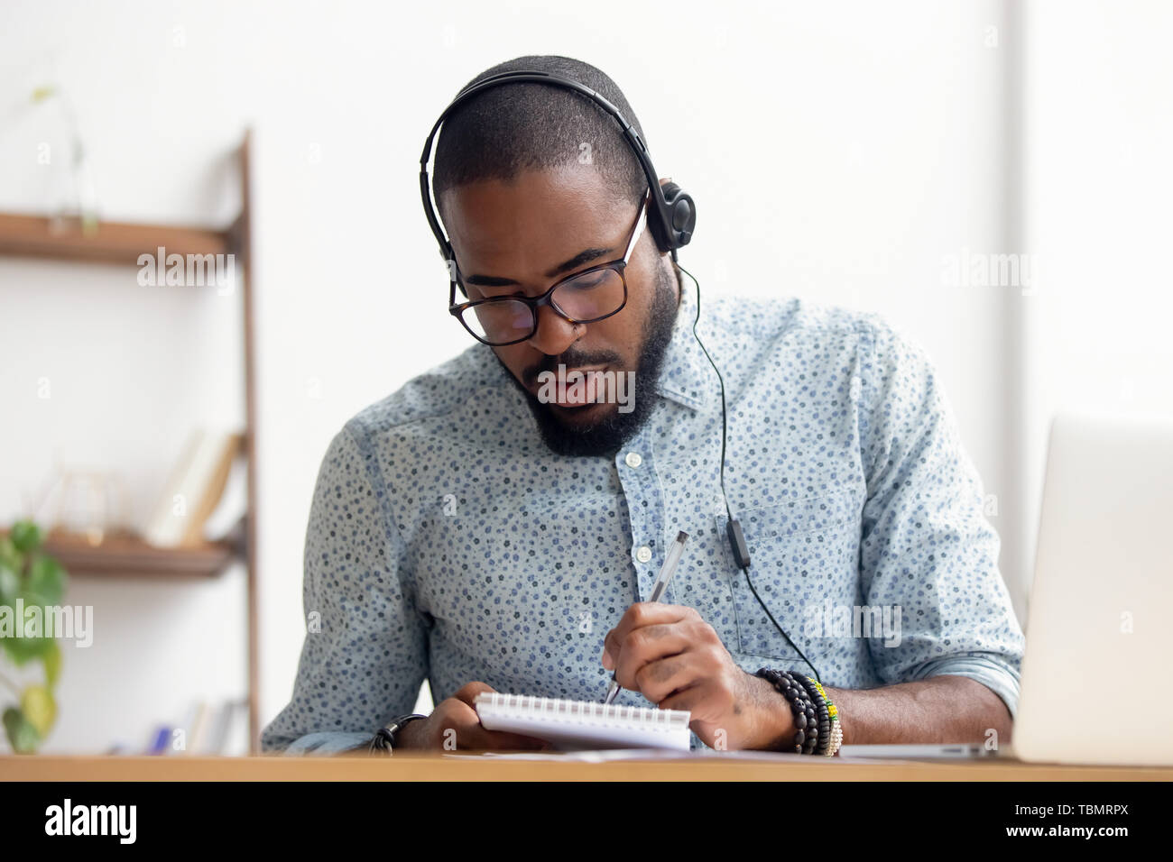 Afrikanische amerikanische Mann im Kopfhörer E-Learning im Büro Stockfoto