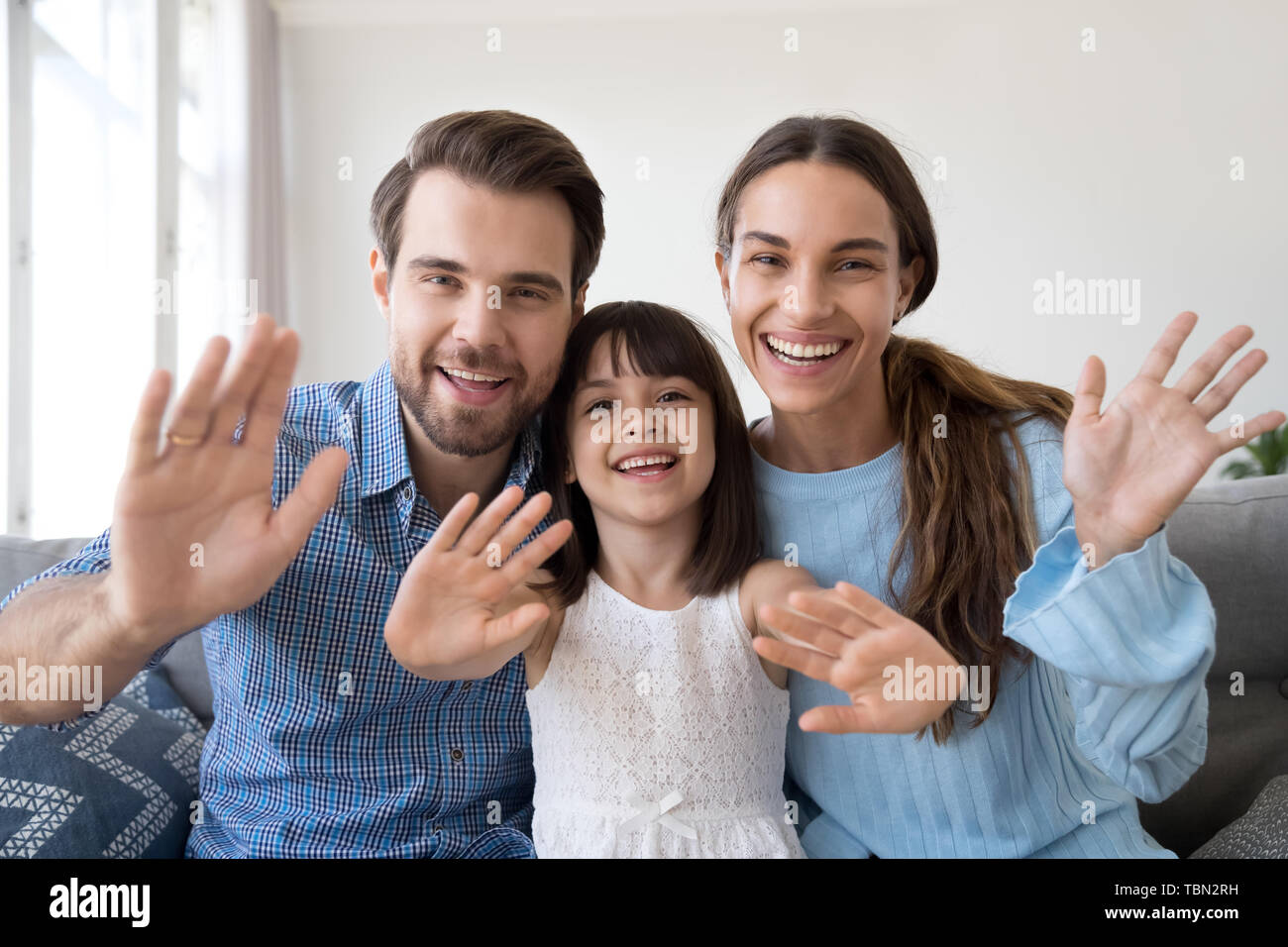 Lächelnd Familie mit Kind winken mit Webcam Stockfoto