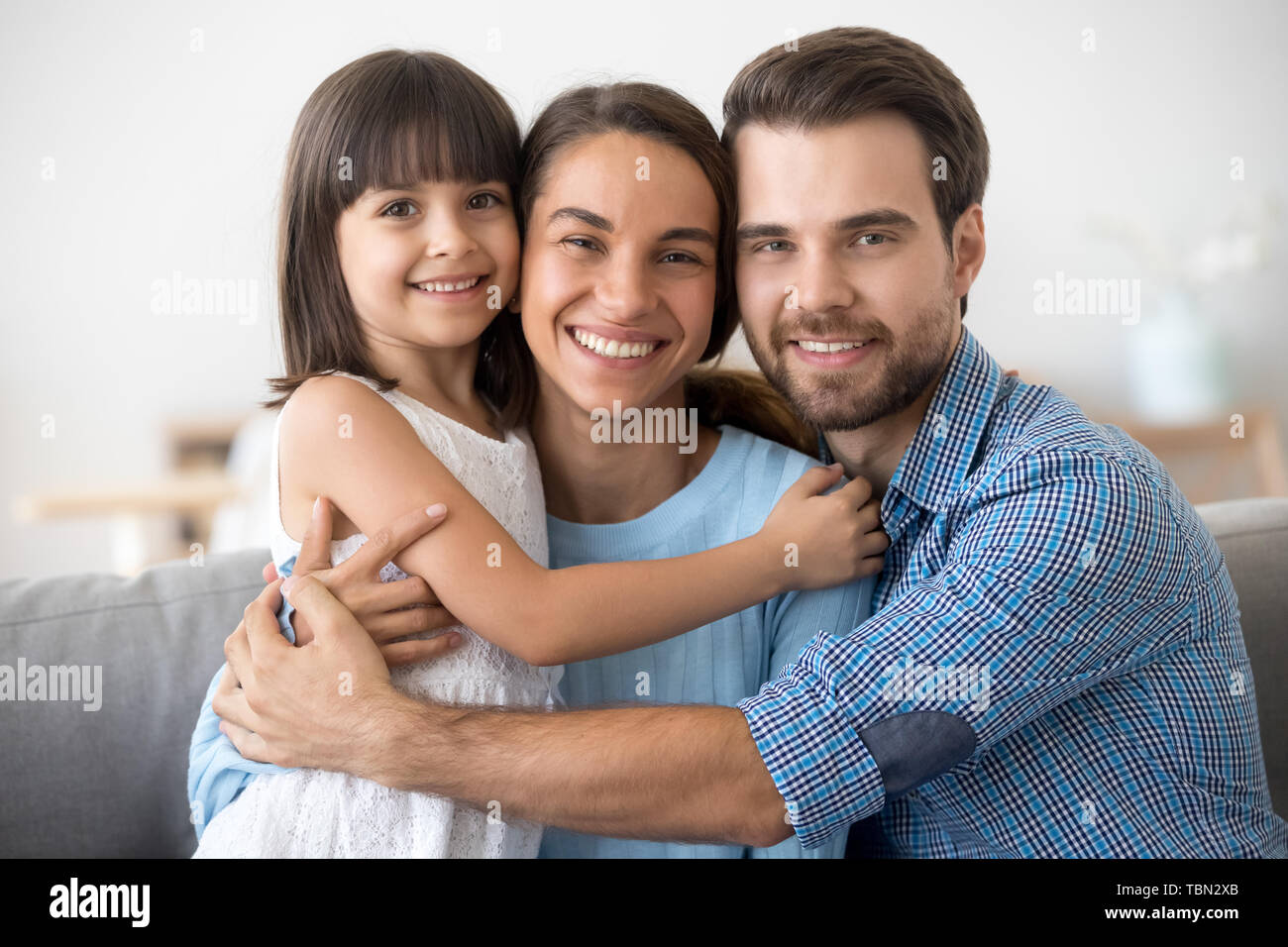 Portrait der glücklichen Familie mit Kind umarmen für Bild posiert Stockfoto