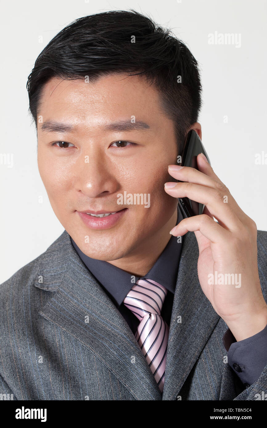 Ein männlicher Angestellter verwendet ein Mobiltelefon. Stockfoto