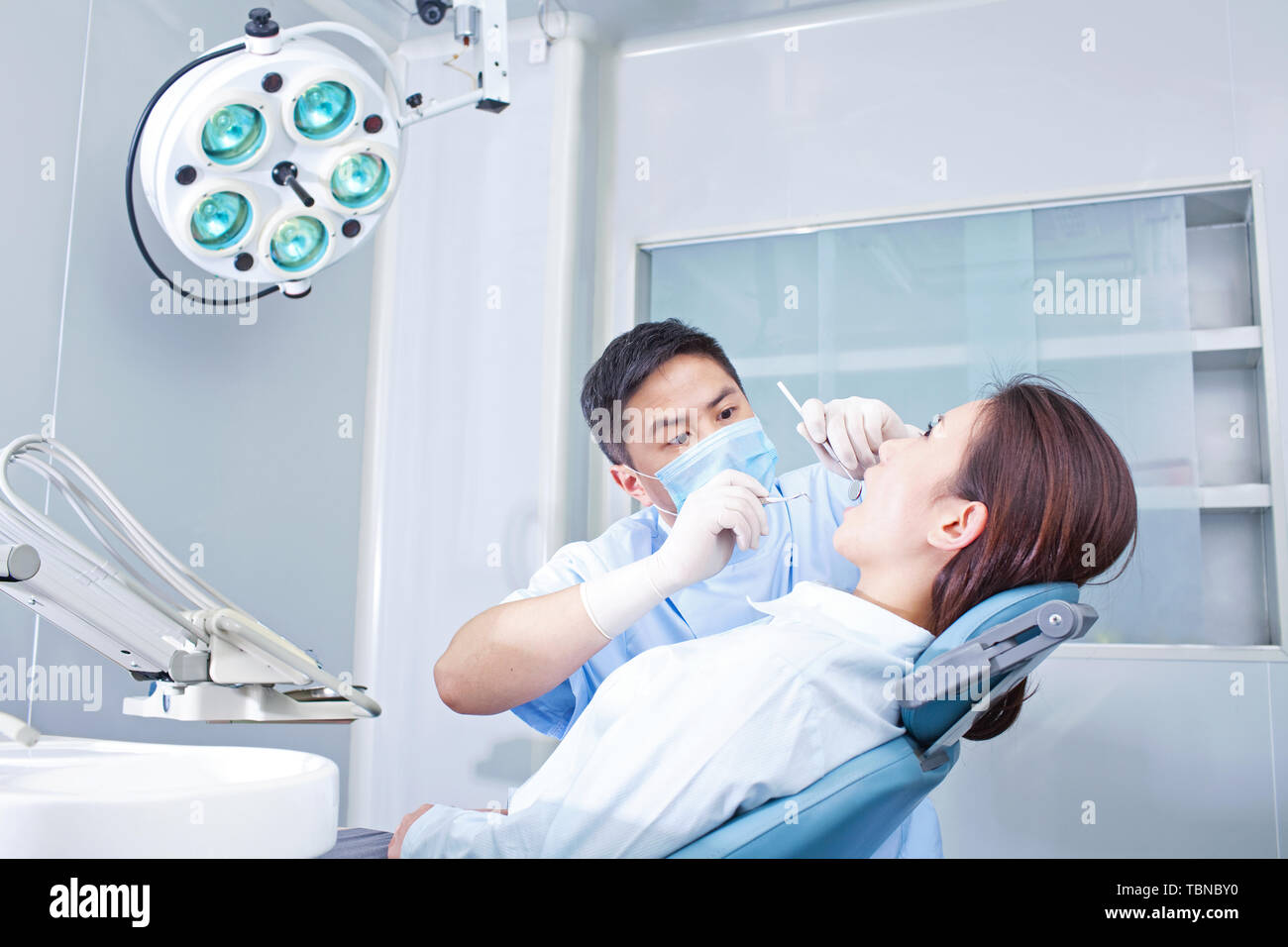 Ärzte behandeln Zähne mit Patienten in der Klinik Stockfoto