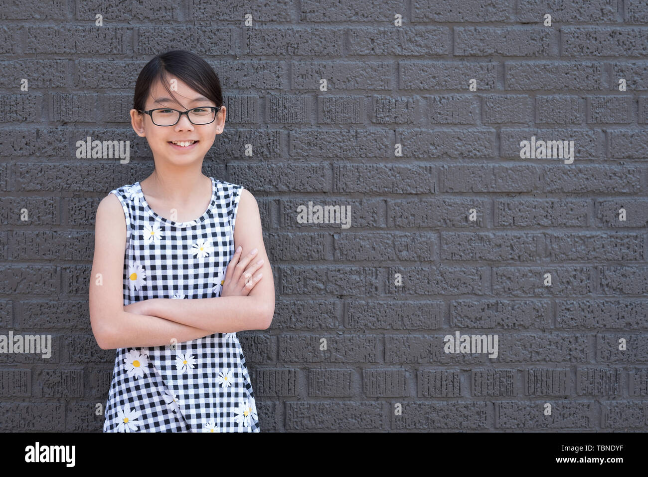 Portrait von jungen asiatischen Mädchen gegen schwarze Wand Stockfoto