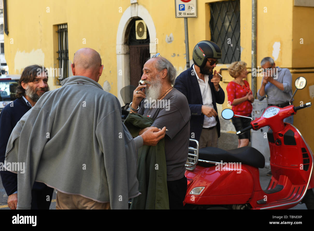 Versammlung der italienischen Männer reden und das Rauchen auf den Straßen von Brescia Italien Stockfoto