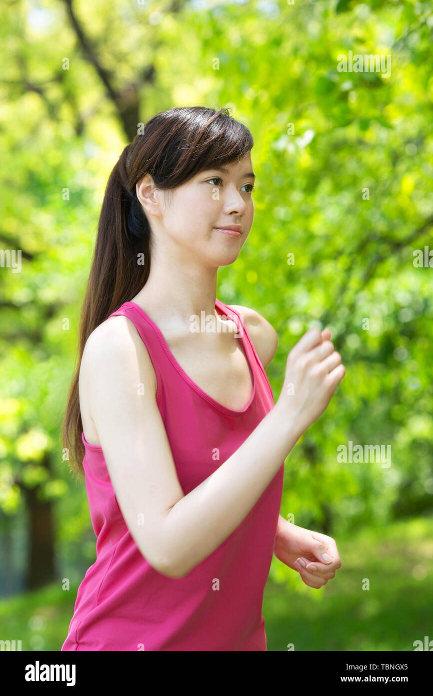 Eine junge Frau führt einen Fitness Übung an einem Sommertag Stockfoto