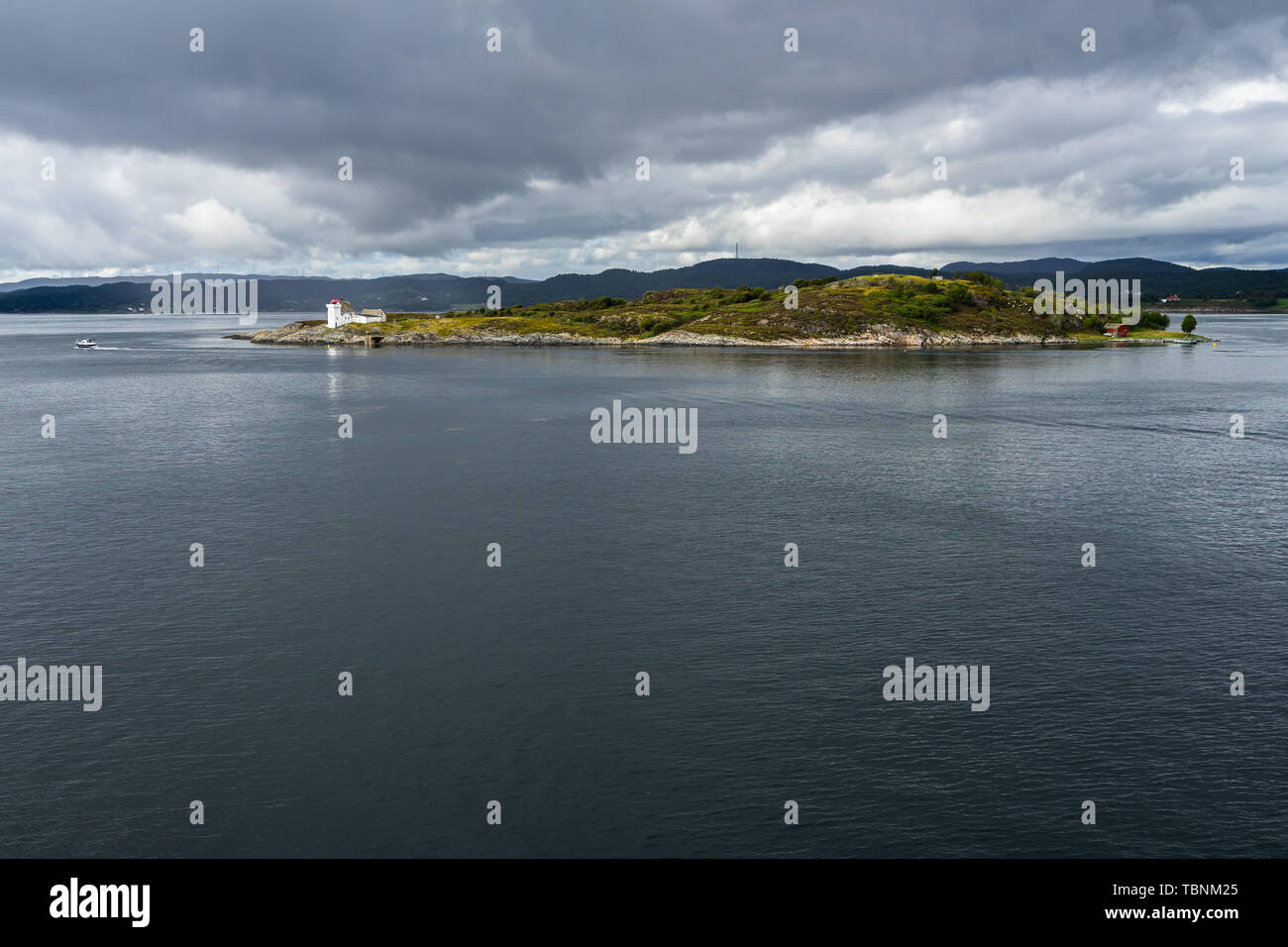 Eine kleine malerische Insel mit einem Leuchtturm von einem Kreuzfahrtschiff in norwegischen Fjord gesehen Stockfoto